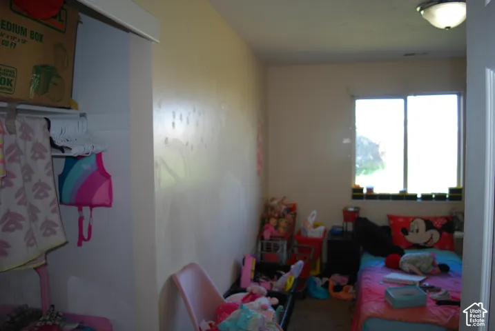 Recessed closet with a single hanging rod, window with a black sill, and a flush-mount ceiling light