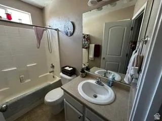 Bathroom featuring a vanity with an integrated sink, large wall mirror, and a combination tub and shower