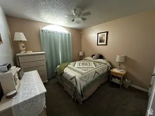 Arched window with light-colored curtains, neutral wall paint, and ceiling fan with lighting