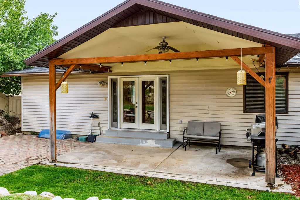 Covered patio featuring a ceiling fan, string lighting, and direct access through a double glass door