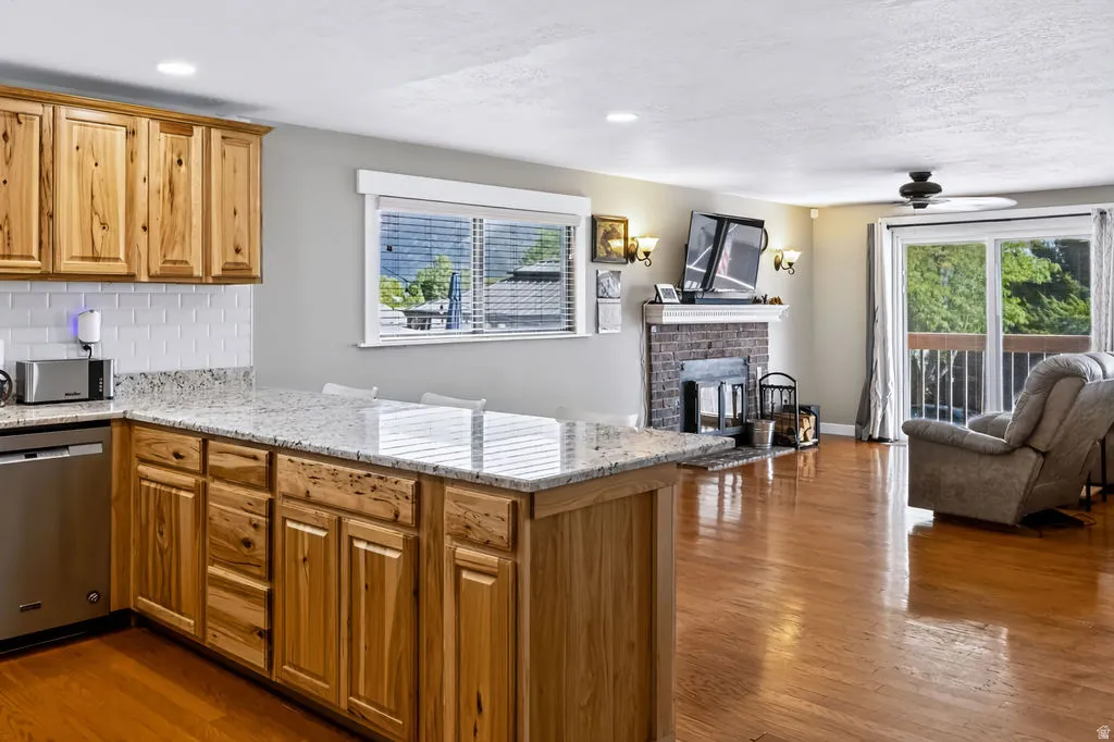 Kitchen with wood cabinetry, light-toned countertops, and a white subway tile backsplash