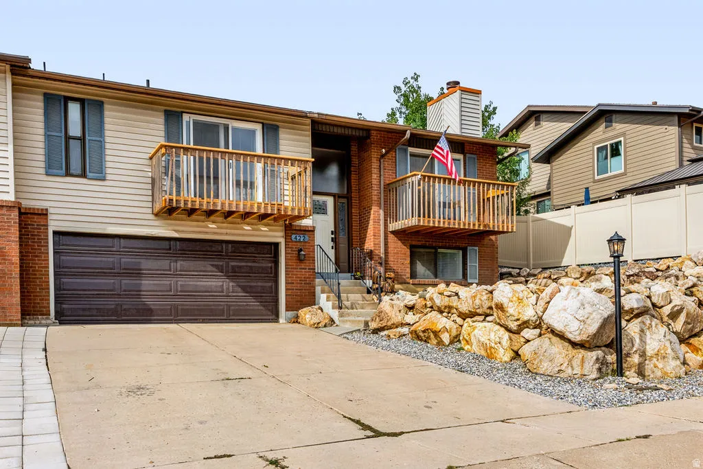 Brick and siding exterior with dual private balconies and a two-car garage