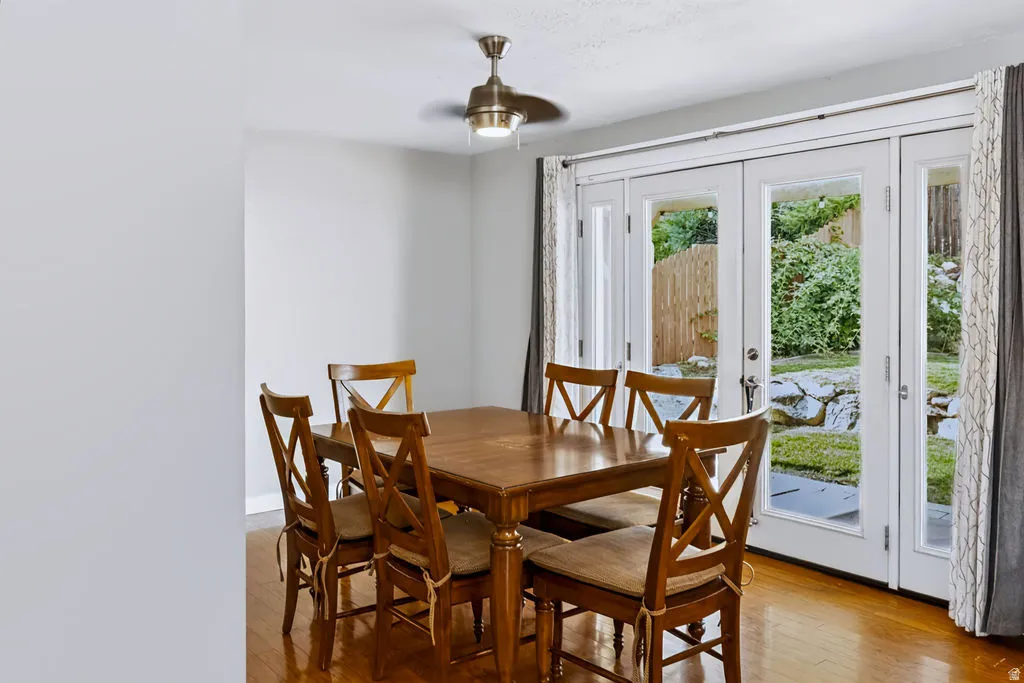 Warm-toned wood-finish flooring, white walls, and a contemporary ceiling fan