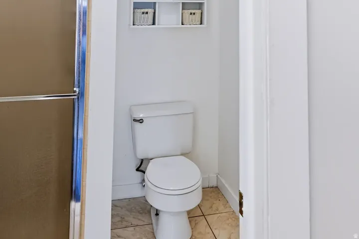 White toilet with tile flooring
