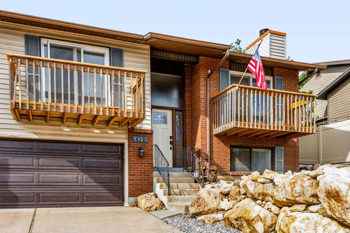 Brick and siding exterior with dual wood-railed balconies