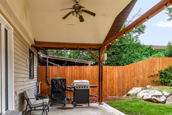 Covered patio featuring a ceiling fan, string lighting, and a concrete surface