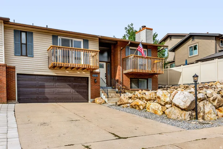 Brick and siding exterior with dual private balconies and a two-car garage