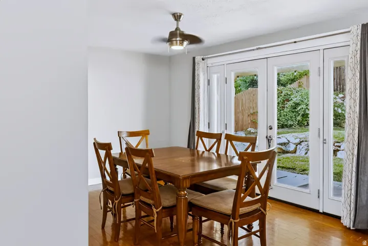 Warm-toned wood-finish flooring, white walls, and a contemporary ceiling fan