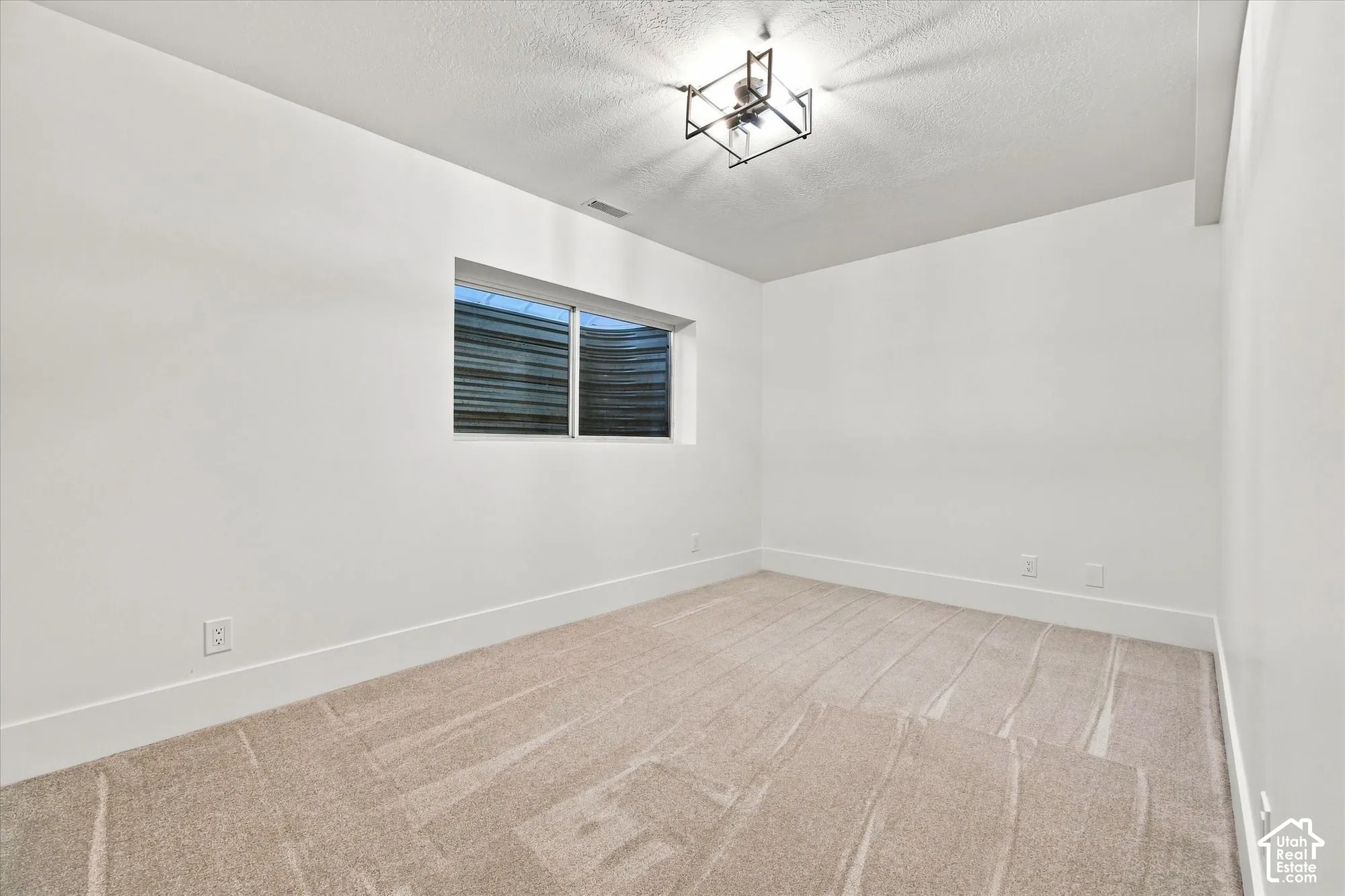 Recessed window with exterior well, neutral carpet, white walls, and a modern ceiling light fixture