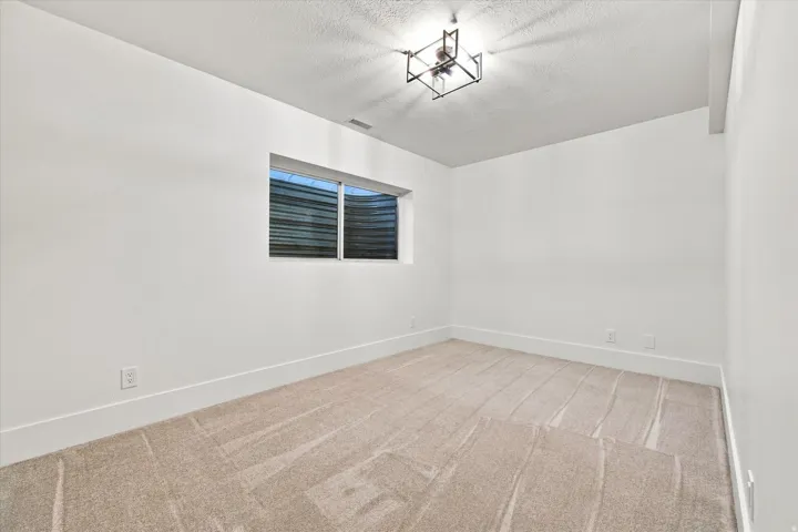 Recessed window with exterior well, neutral carpet, white walls, and a modern ceiling light fixture