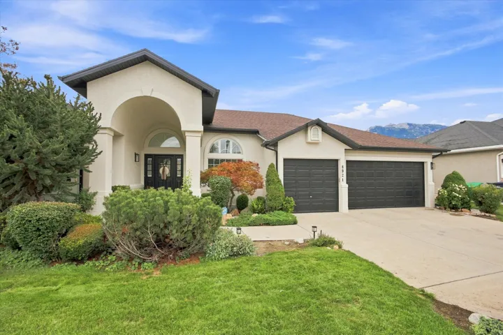 Stucco exterior with a covered entry, arched windows, and a two-car garage