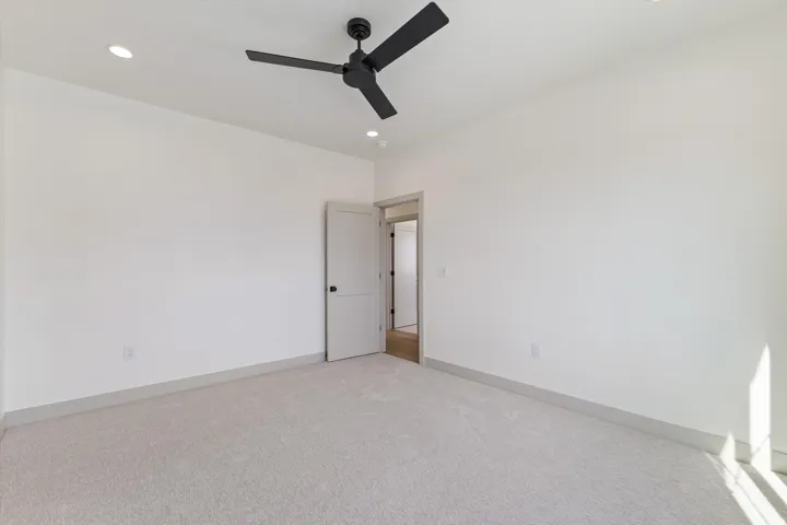 Recessed lighting, ceiling fan, white walls, light gray carpeting, and gray baseboards