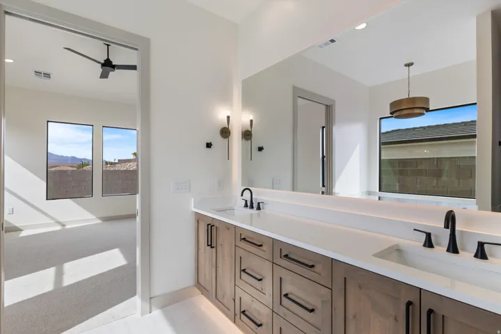 Dual vanity with undermount sinks, stone countertops, and matte black fixtures
