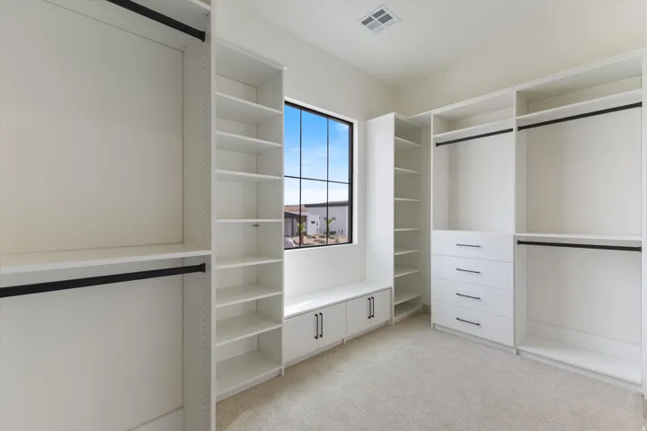 Custom closet system featuring multiple hanging rods, integrated shelving, and built-in drawers
