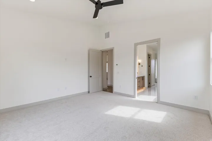 Spacious room featuring light-toned carpeting, high ceilings, recessed lighting, and a contemporary ceiling fan