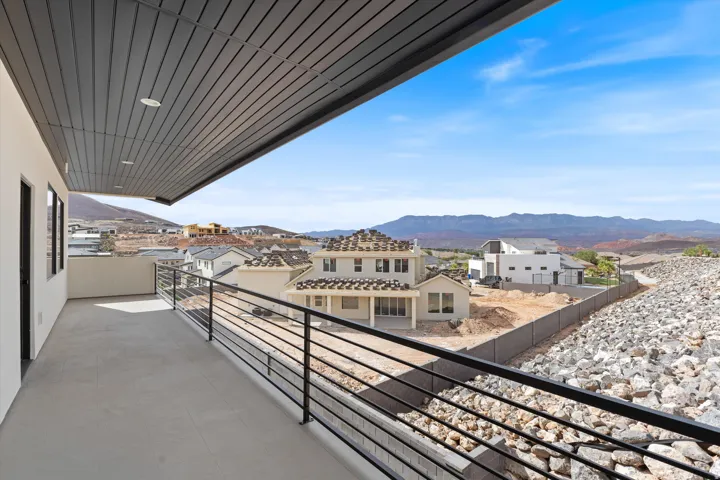 Expansive outdoor balcony with a slatted ceiling, recessed lighting, and black metal railings