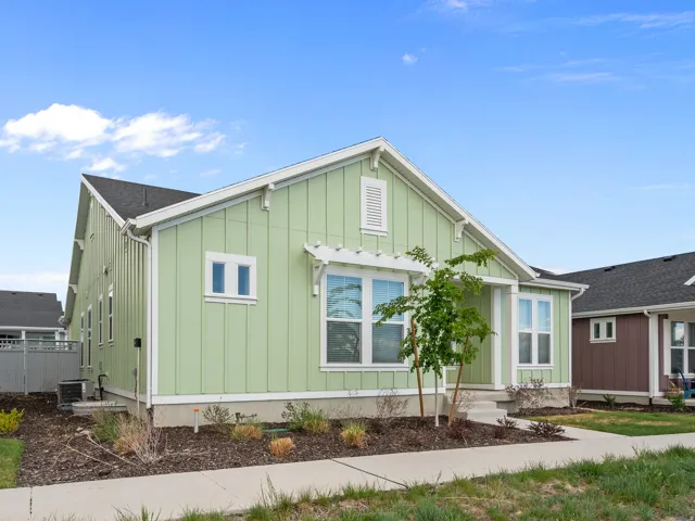 Board and batten siding, front entry, white trim, pergola accent, and pitched roof