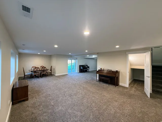 Expansive open-concept room featuring recessed lighting, light-toned walls, and carpet flooring