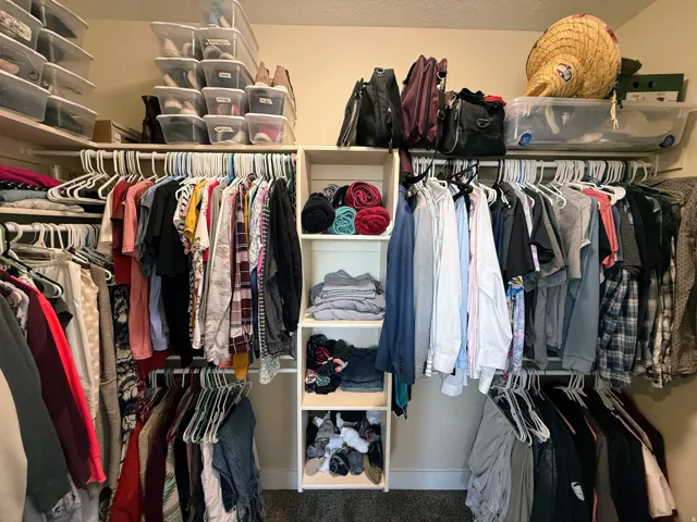 Built-in closet system featuring multiple hanging rods, overhead shelving, and integrated vertical shelving units