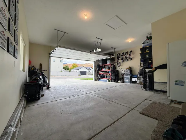 Concrete flooring, overhead lighting, and an overhead garage door