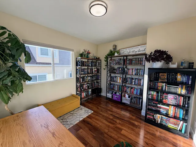 Wood-finish flooring, recessed lighting, and a large window providing ambient light