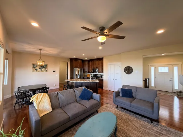 Open-concept living area with dark wood-finish flooring, recessed lighting, and a ceiling fan