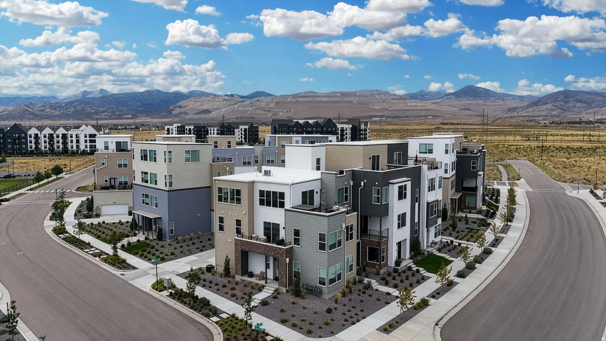 Modern multi-story residences featuring diverse exterior finishes, private balconies, and integrated garages
