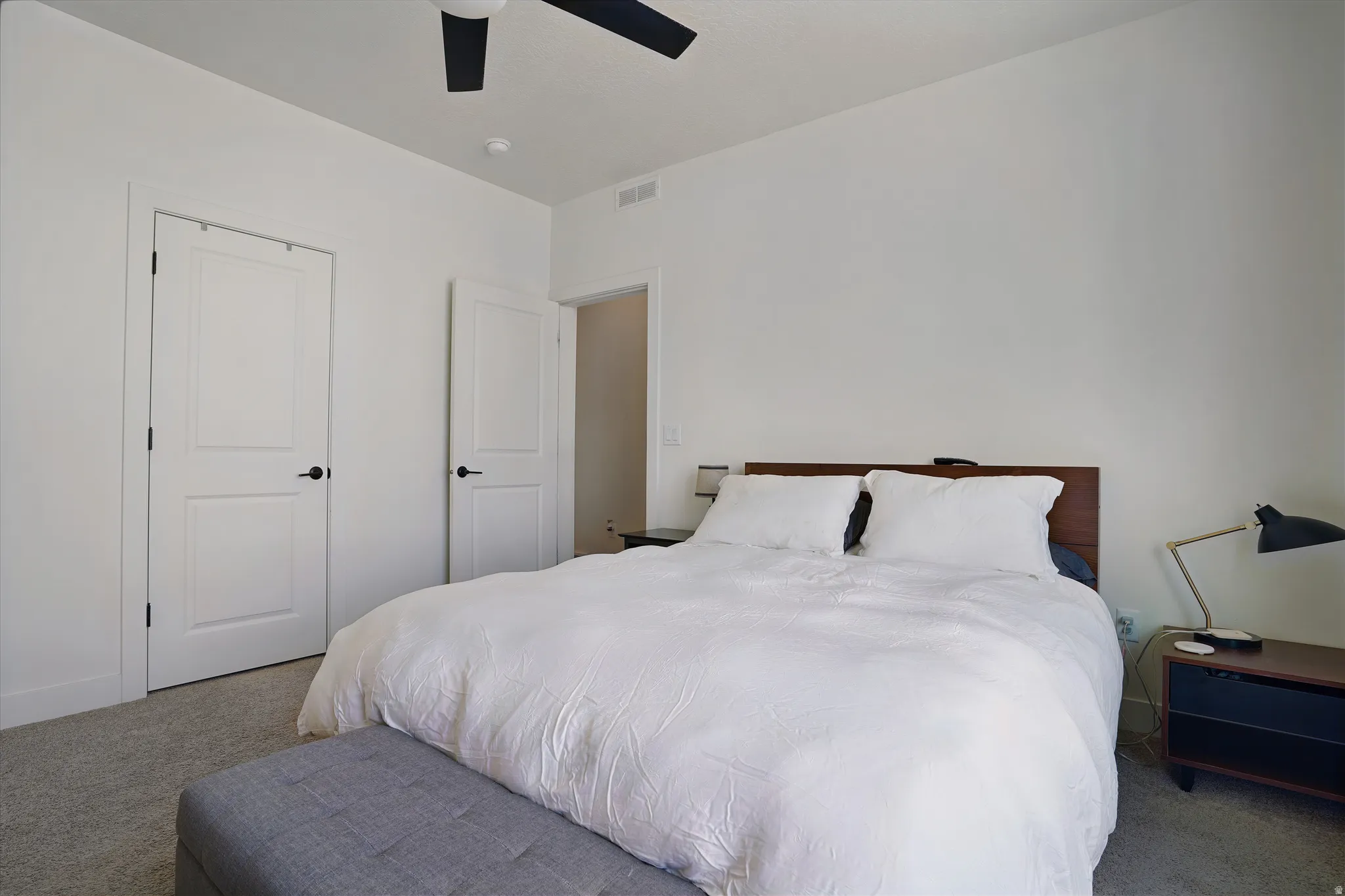 White paneled doors with black hardware, recessed lighting, and a dark-bladed ceiling fan