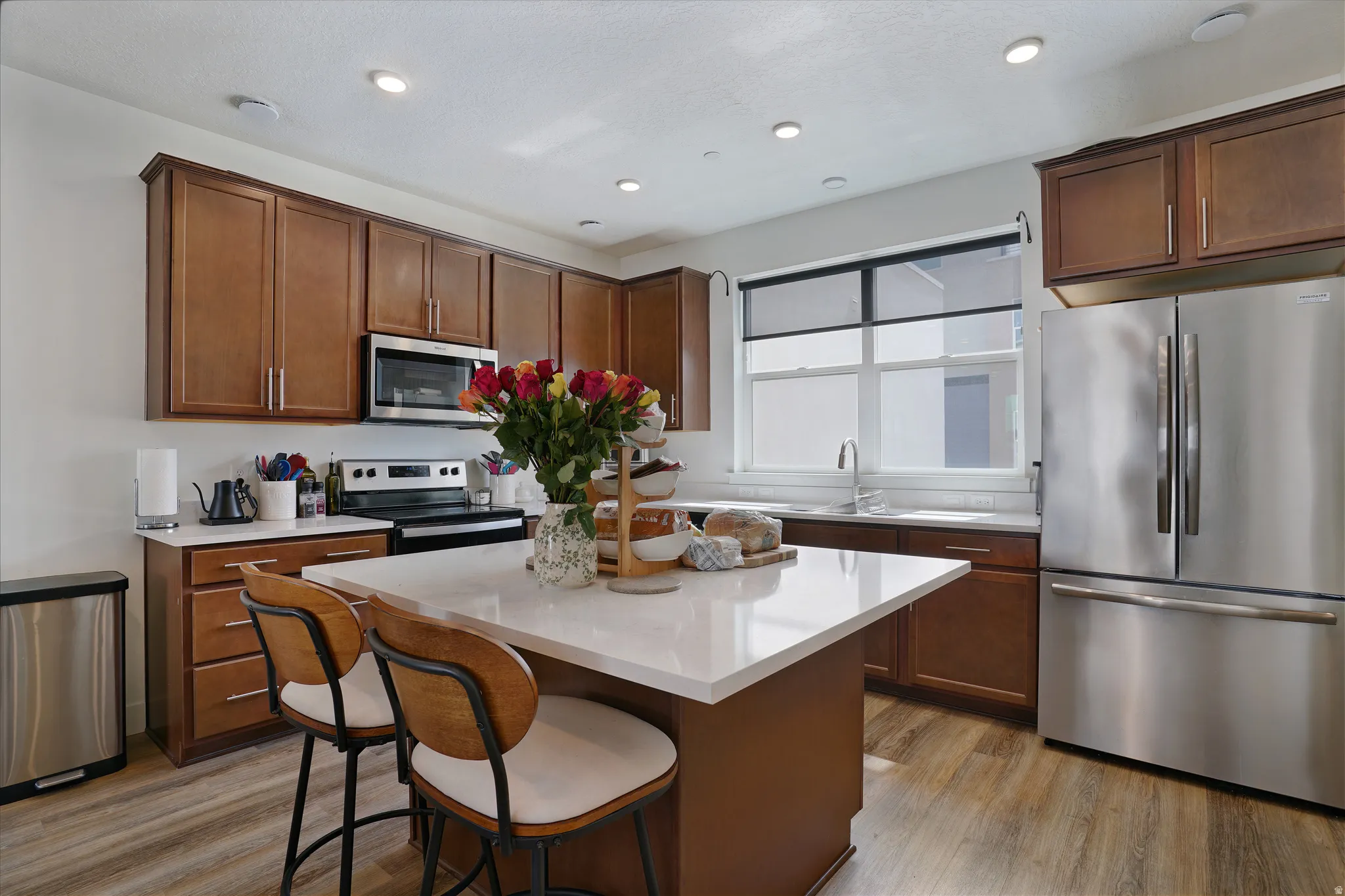 Kitchen featuring wood-finish flooring, recessed lighting, and a center island with a white countertop