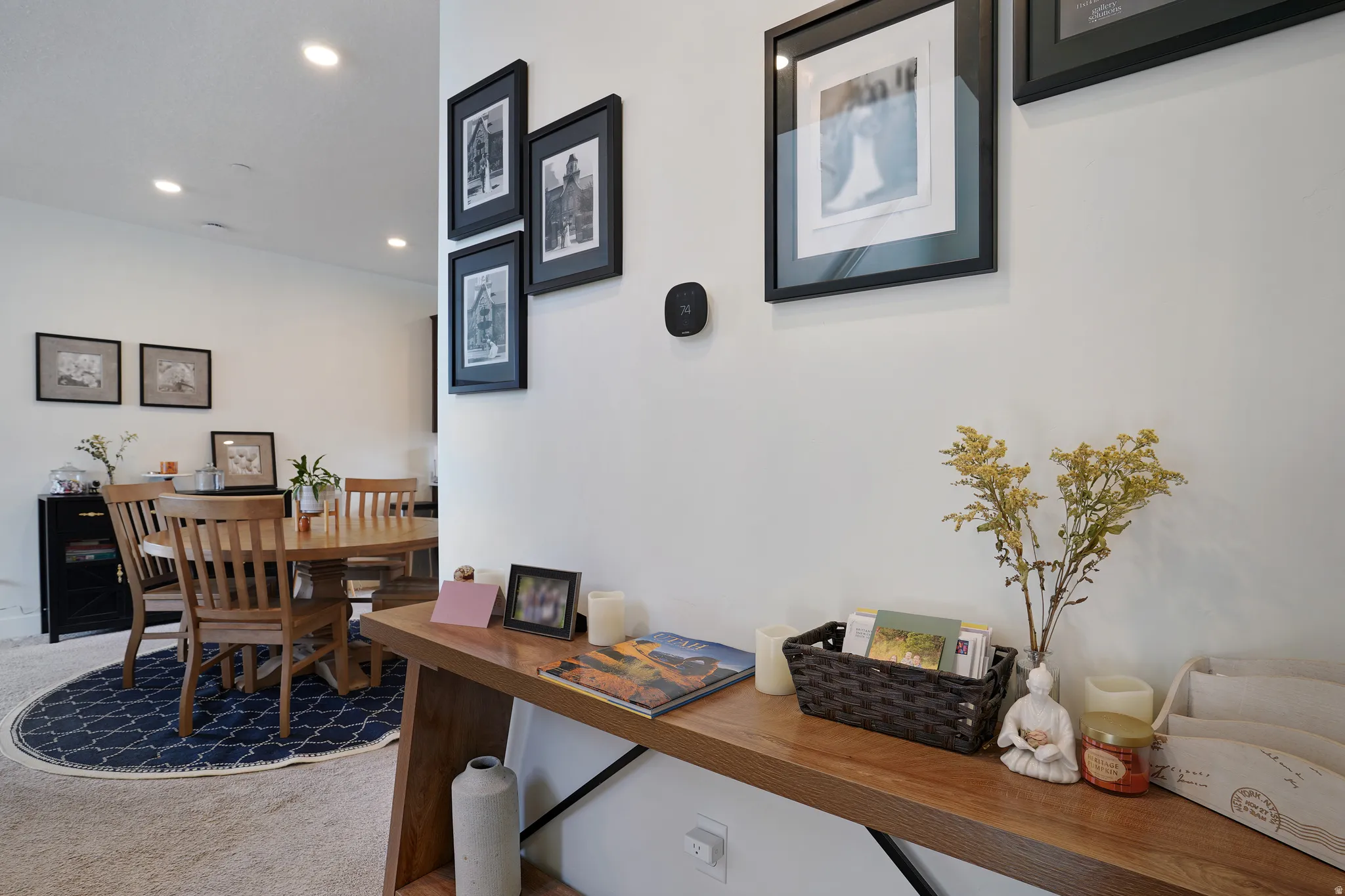 Recessed lighting, light neutral-toned walls, and wood-finish console table