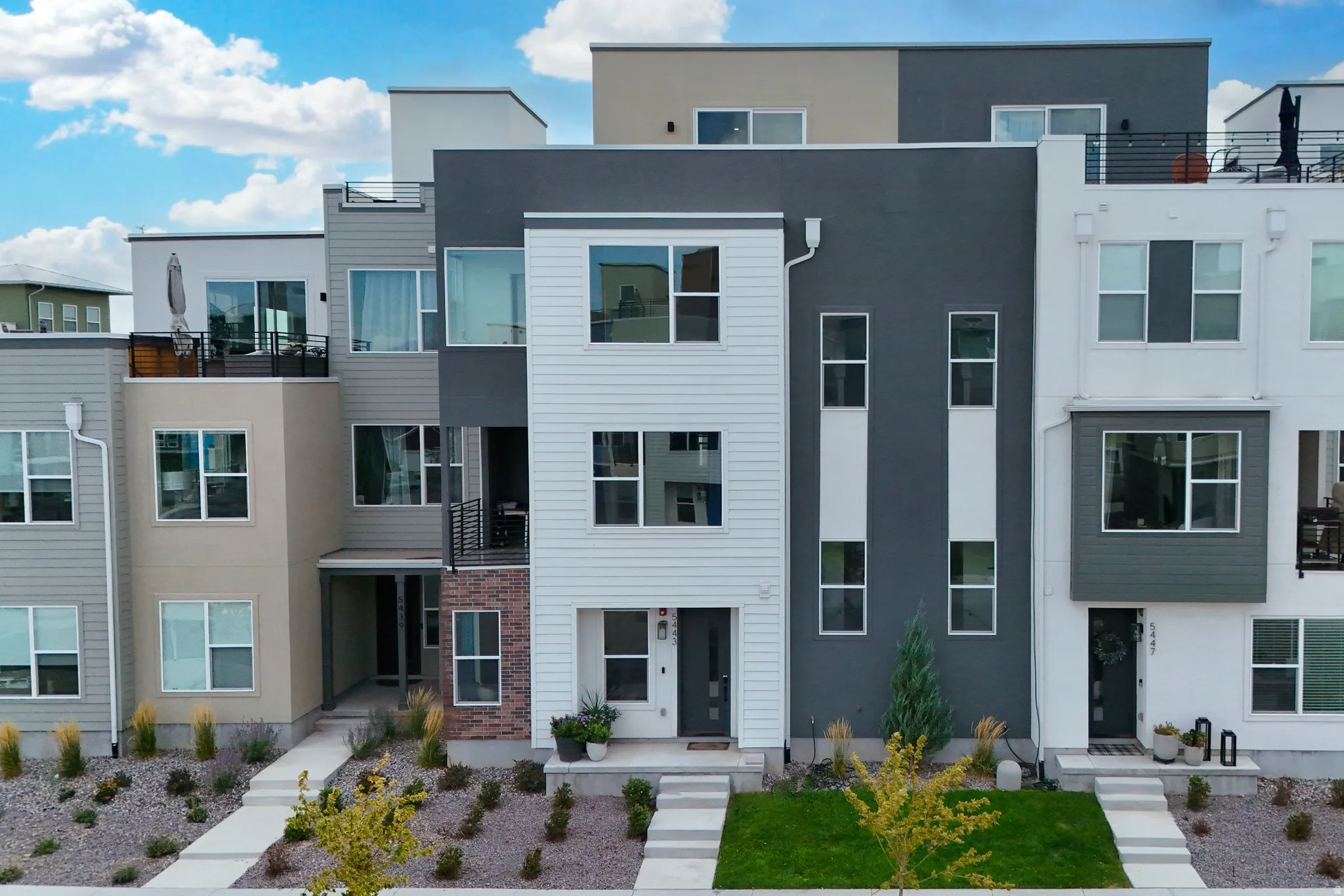 Contemporary multi-level townhome featuring a mixed-material facade with siding and stucco