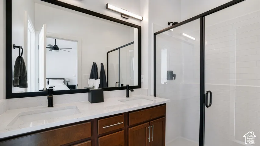 Dual vanity with integrated sinks, dark wood-finish cabinetry, and matte black hardware