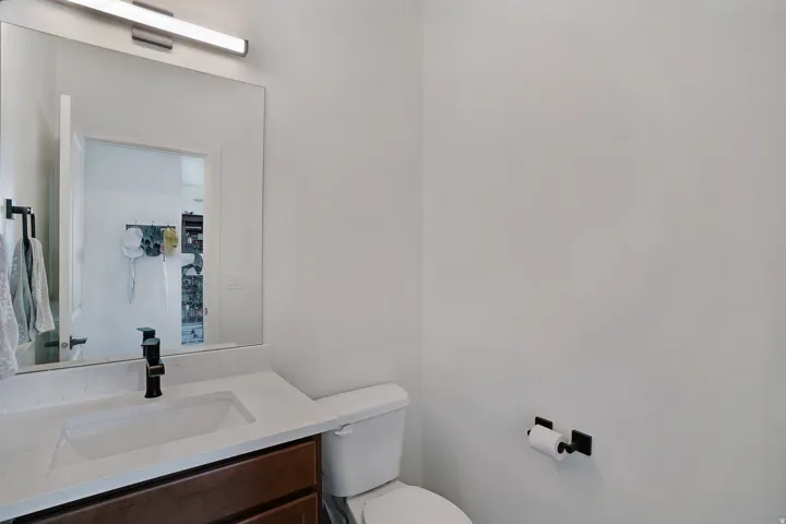 Modern bathroom featuring a floating vanity with an integrated rectangular sink, white quartz countertop, and matte black wall-mounted faucet hardware