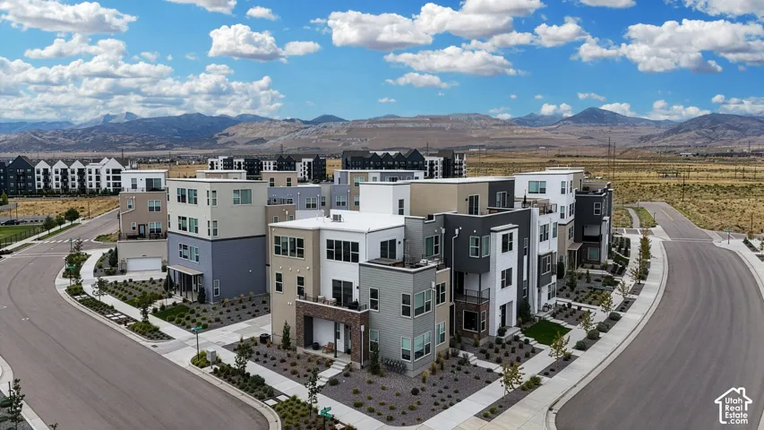 Modern multi-story residences featuring diverse exterior finishes, private balconies, and integrated garages