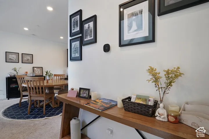 Recessed lighting, light neutral-toned walls, and wood-finish console table