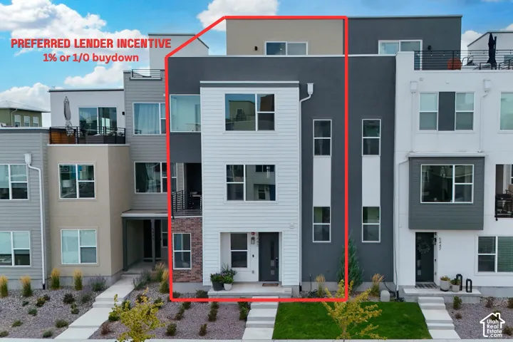 Modern townhome with multi-level windows, a recessed entry, and vertical siding accents