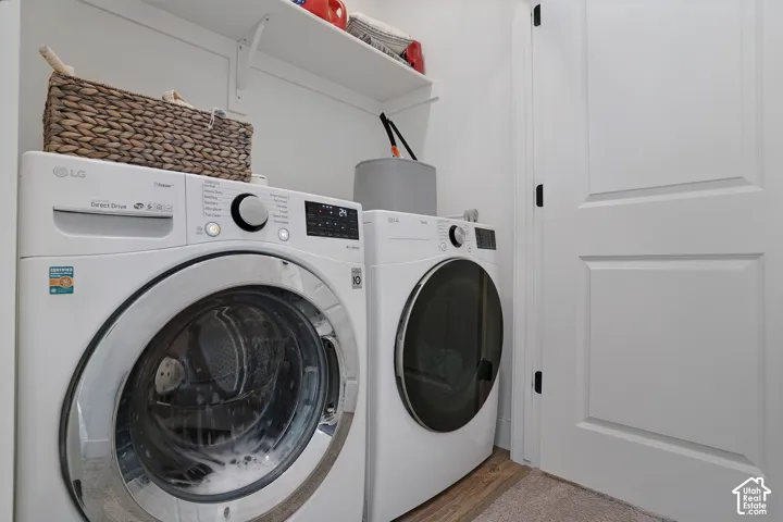 White shaker-style doors with black hardware, wood-finish flooring, and wall-mounted shelving