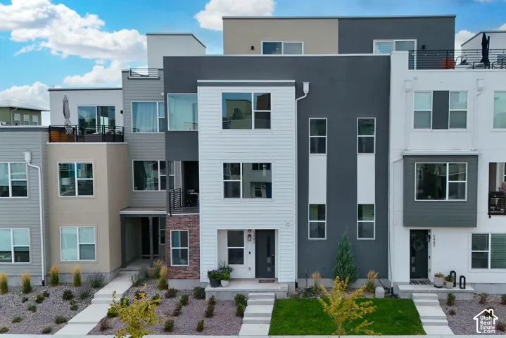 Contemporary multi-level townhome featuring a mixed-material facade with siding and stucco