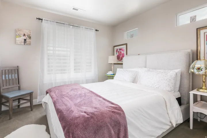 Carpeted room with a large window and upper transom windows