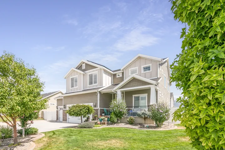 Two-story Colonial-style home featuring a composite or fiber cement exterior with board-and-batten accents, multiple gabled rooflines, and substantial front-facing windows