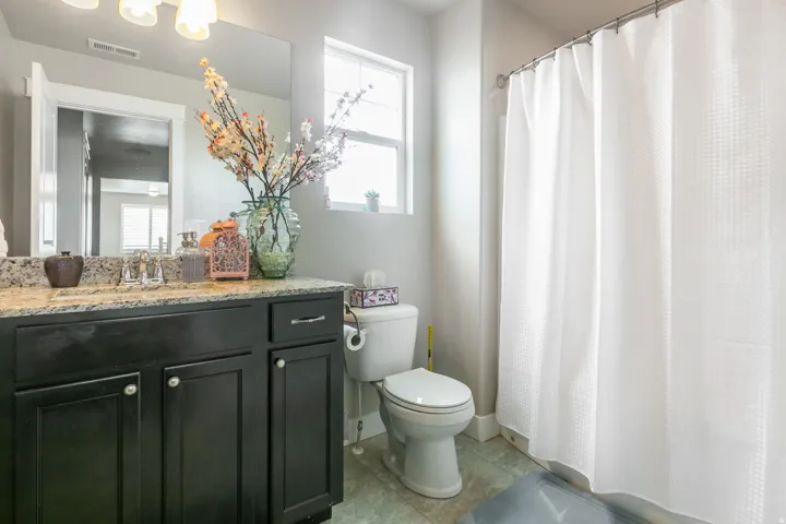Bathroom featuring a dark wood-finish vanity with a light-toned countertop, a built-in sink, and an overhead light fixture