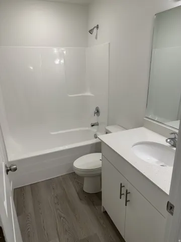 Bathroom featuring a white vanity with an integrated sink, polished chrome faucet, and a wall-mounted mirror