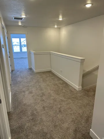 Plush carpet flooring, recessed ceiling lighting, white painted walls, and white trim