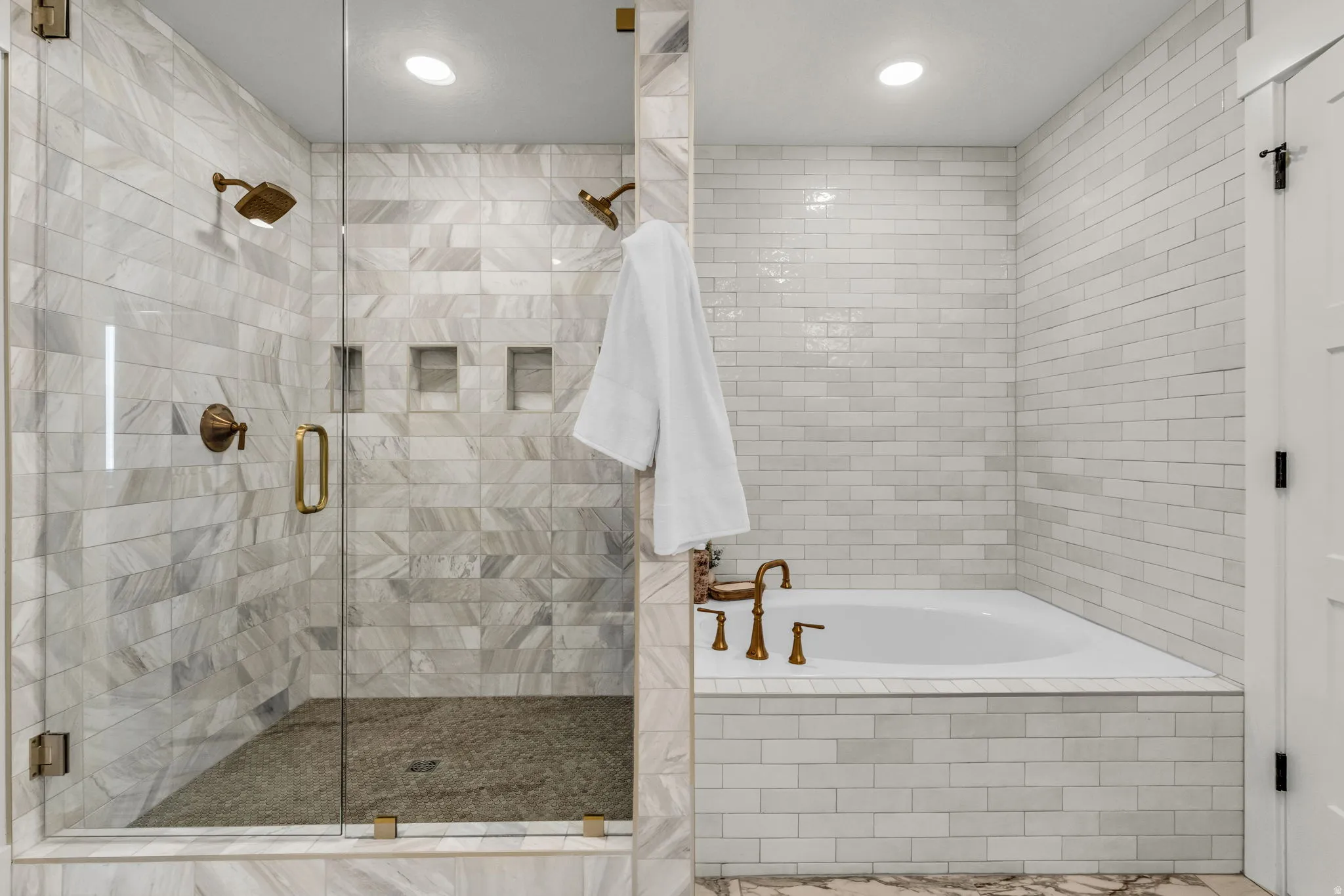 Glass-enclosed shower with multiple shower heads and integrated wall niches