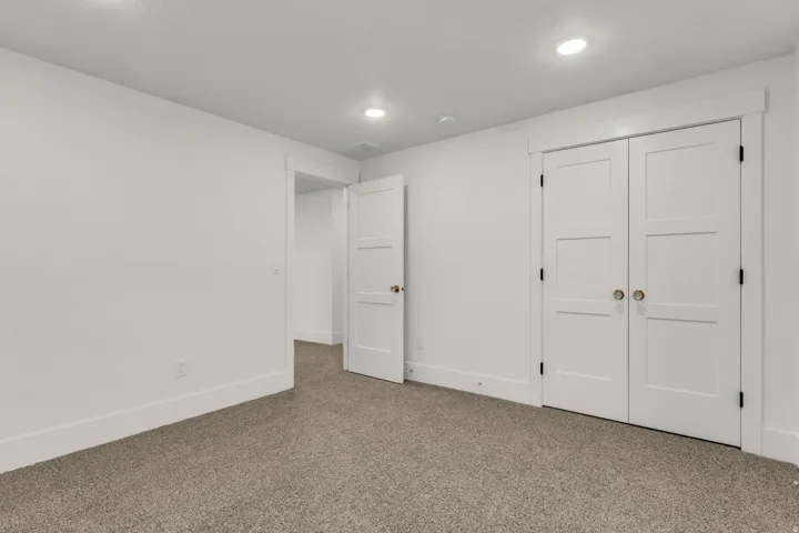 Recessed ceiling lighting, white interior doors, and neutral carpeting