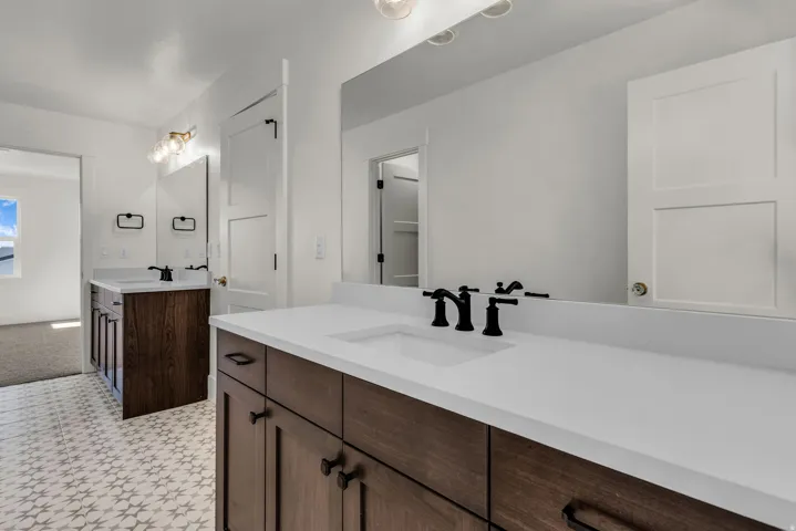 Dual wood-finish vanities with white countertops and integrated sinks