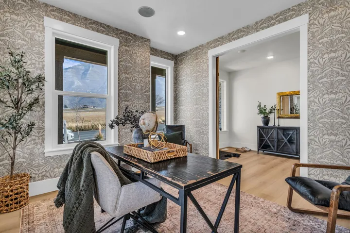 Patterned wallpaper, recessed lighting, wood-finish flooring, white window trim, and a mountain backdrop