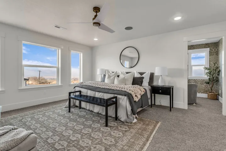 Recessed lighting, ceiling fan, white walls, carpet flooring, and a cased opening to an additional room