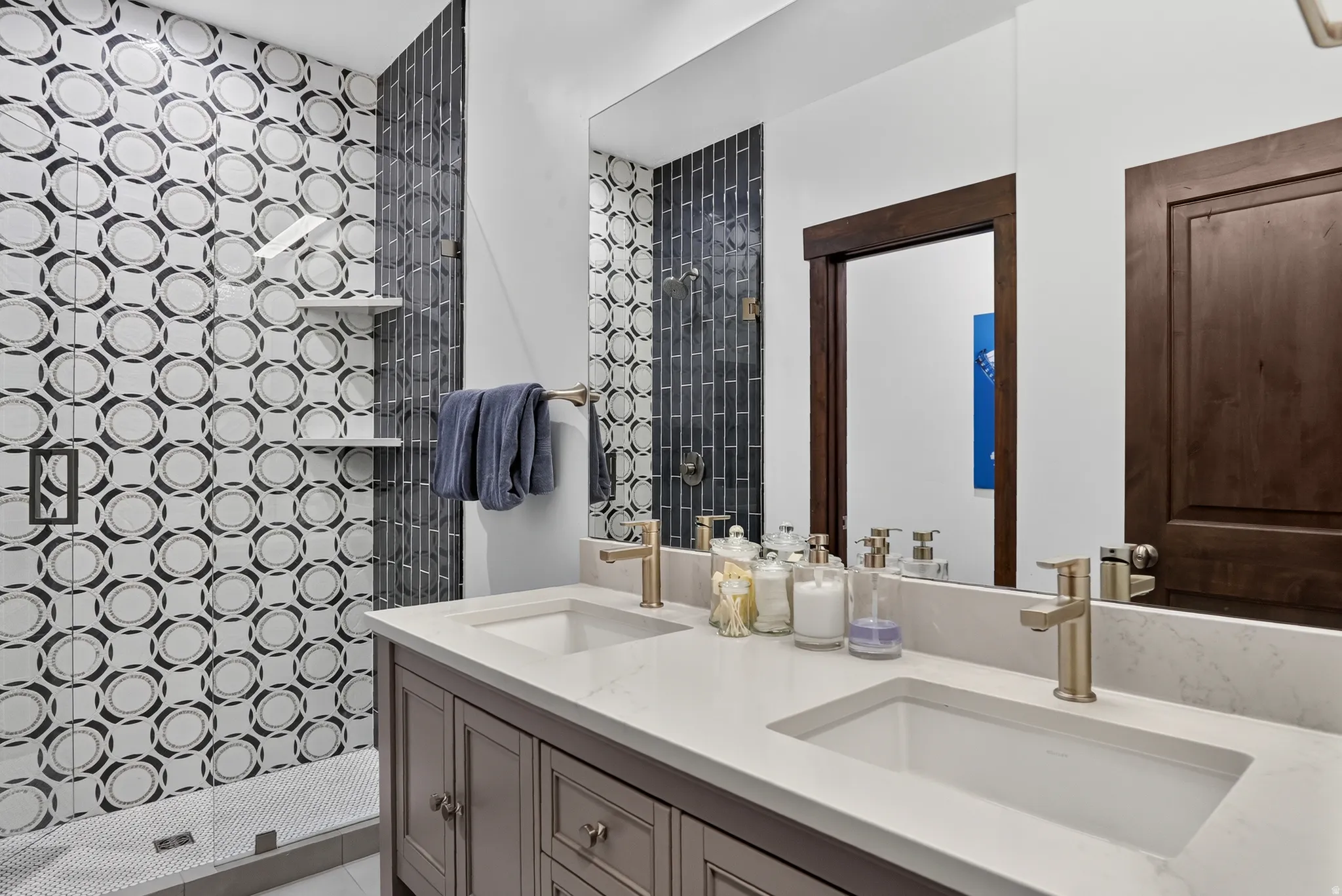 Dual vanity with integrated sinks, brushed gold-finish faucets, and a stone countertop