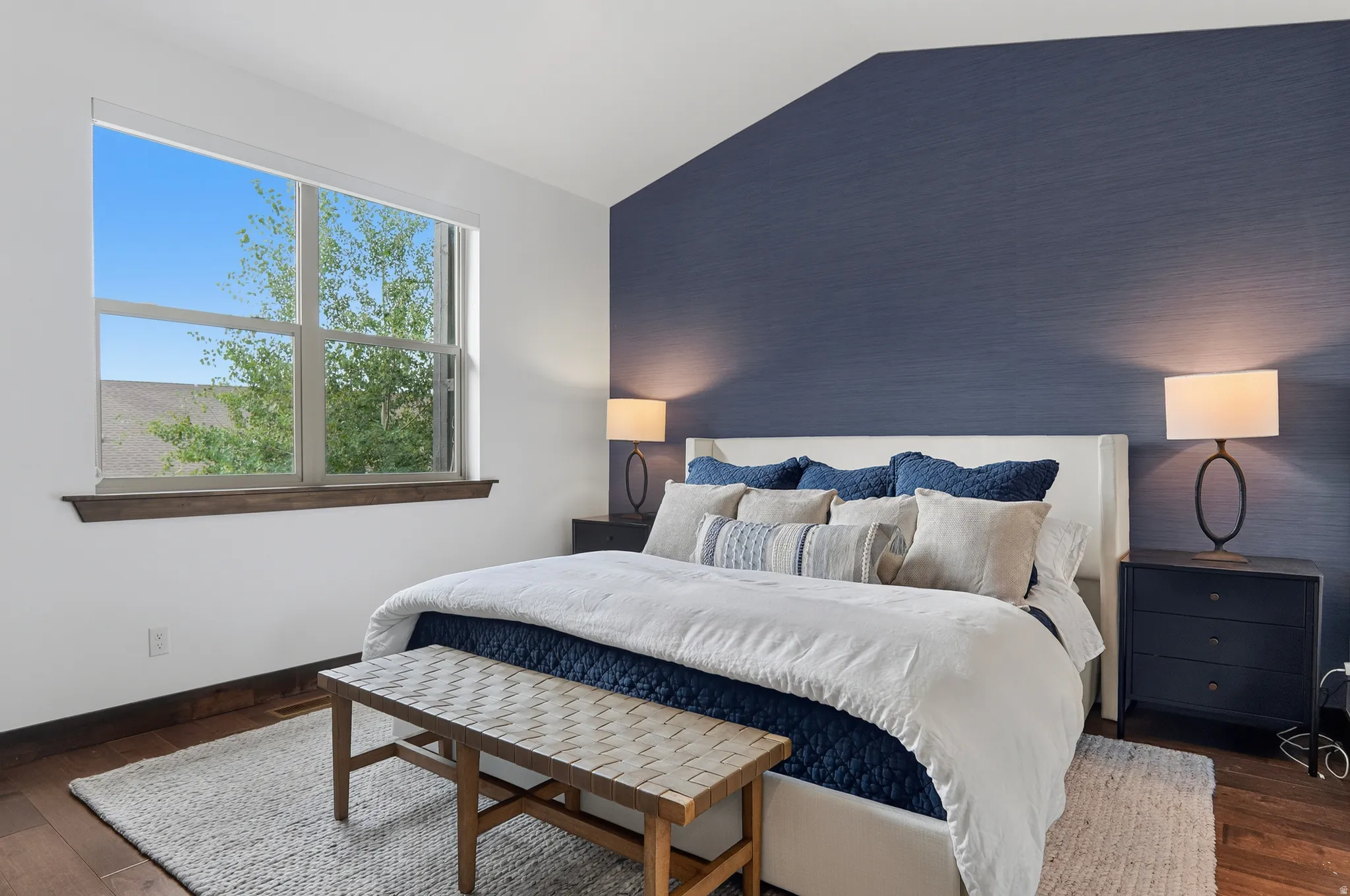 Hardwood flooring, expansive window, wood window sill, textured accent wall, and recessed lighting
